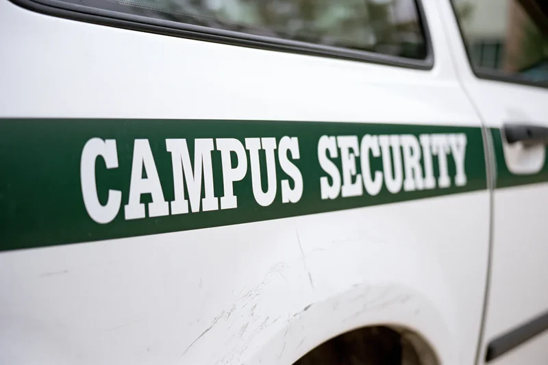 Close-up of white campus security vehicle door with green stripe and lettering