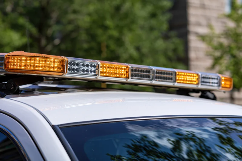 Amber and white led light bar mounted on top of a police vehicle outdoors
