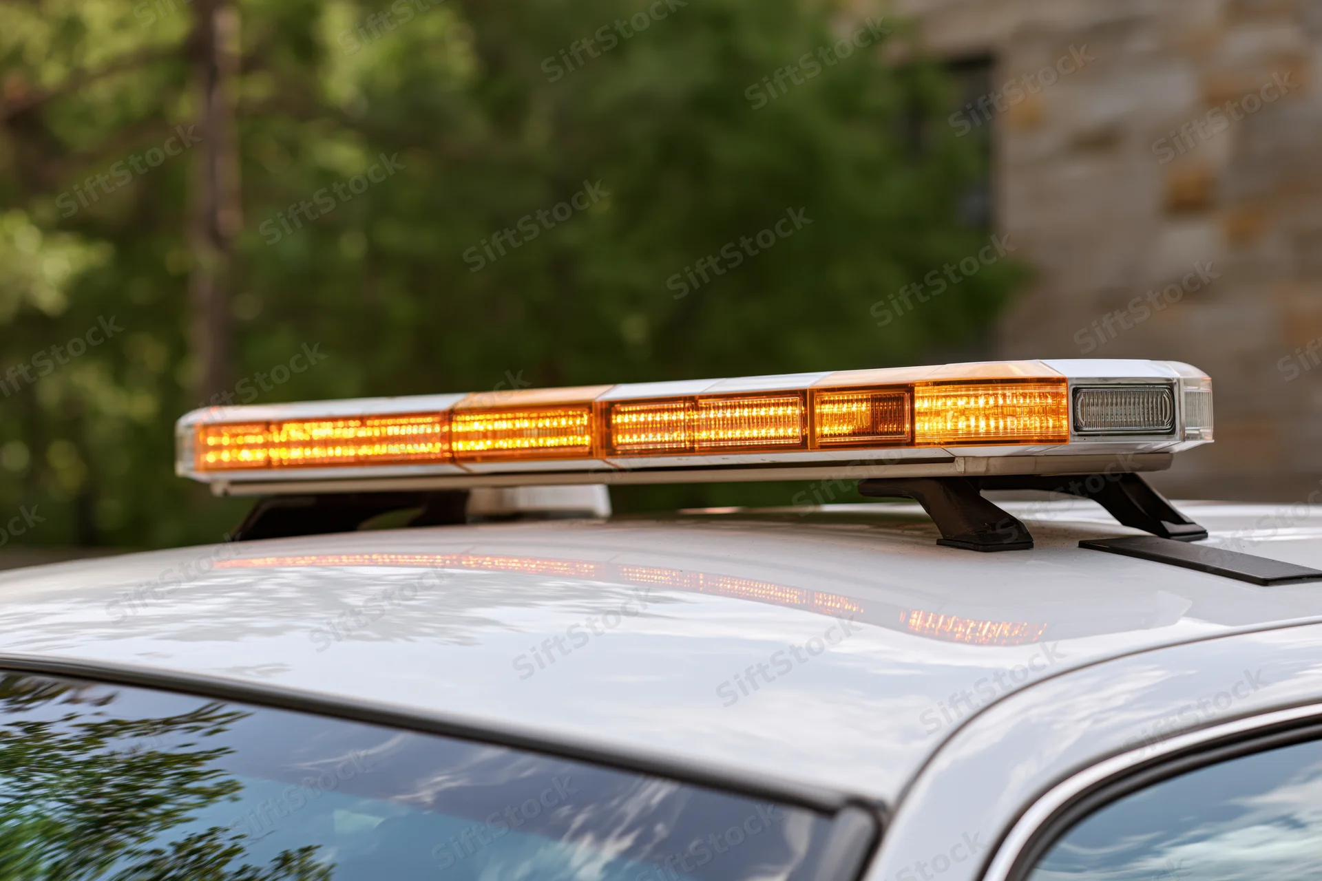 Amber and white led light bar mounted on top of a white emergency vehicle outdoors
