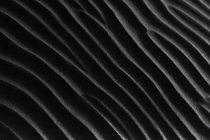 Close-up of rippled black volcanic sand dunes formed by wind erosion