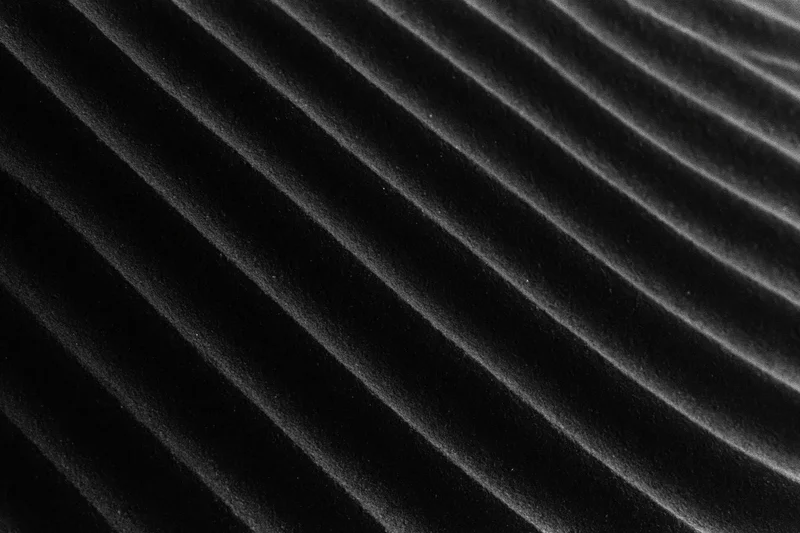 Close-up of rippled black volcanic sand dunes formed by wind erosion