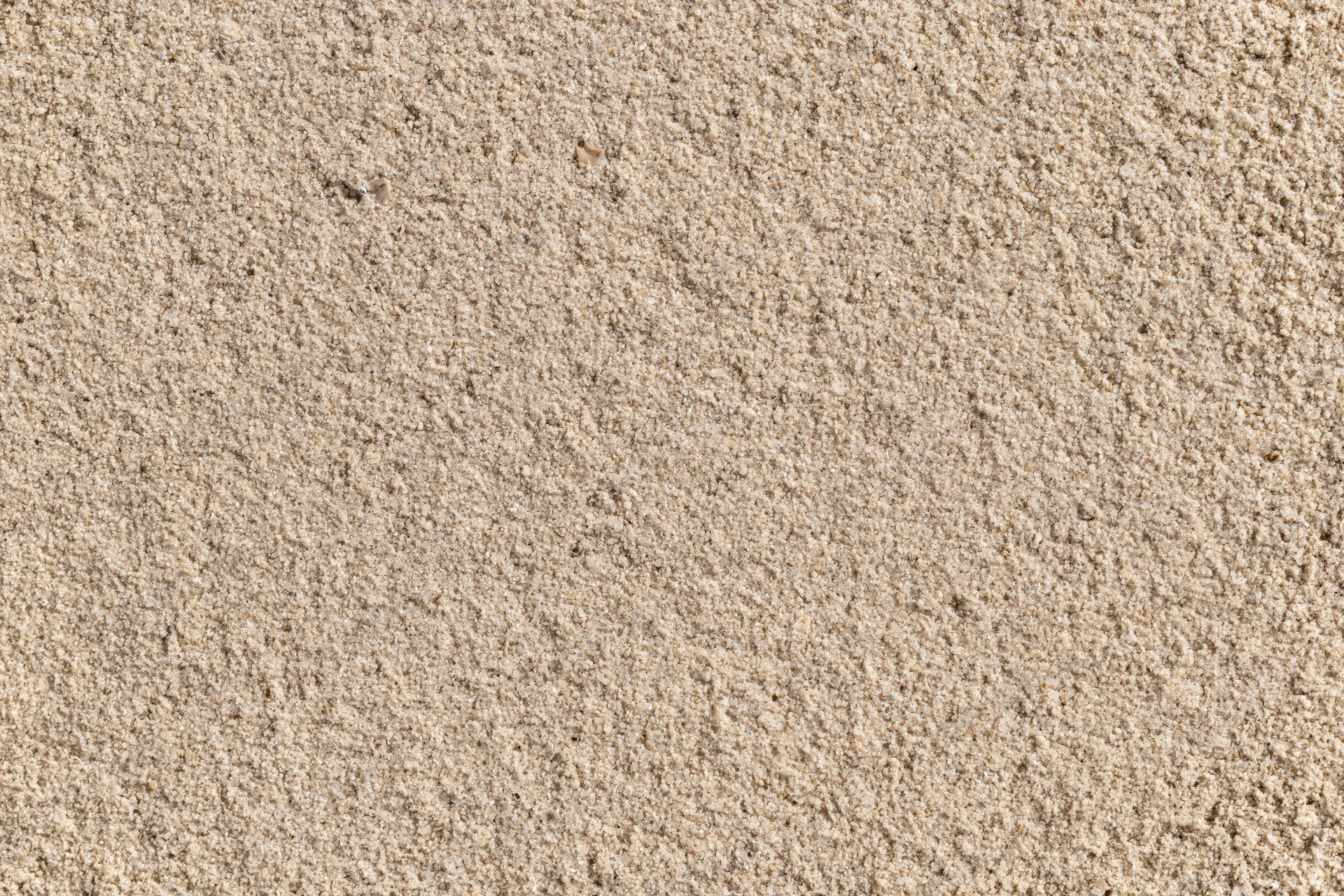 Closeup overhead view of dry beach sand texture filling the frame