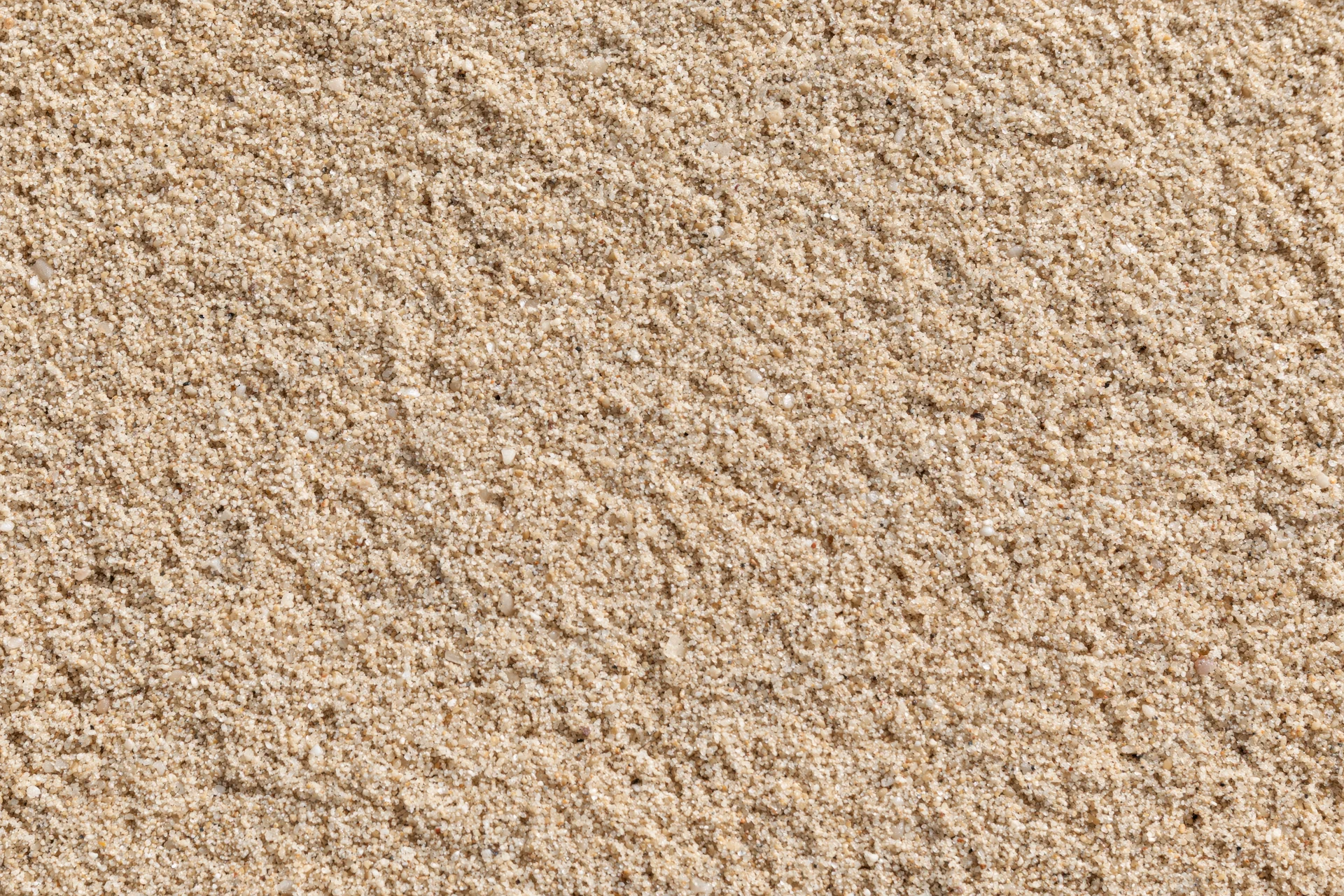 Closeup overhead view of dry beach sand texture filling the frame