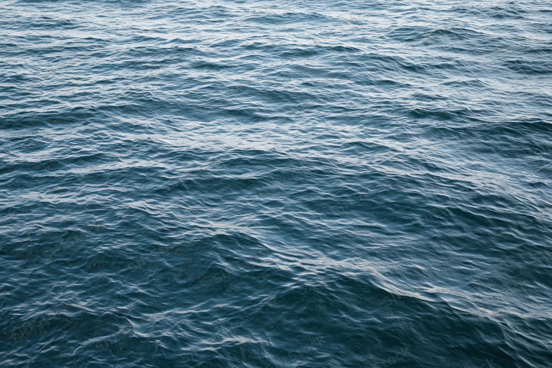 Overhead view of calm ocean water surface with gentle ripples and waves