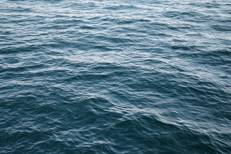 Overhead view of calm ocean water surface with gentle ripples and waves