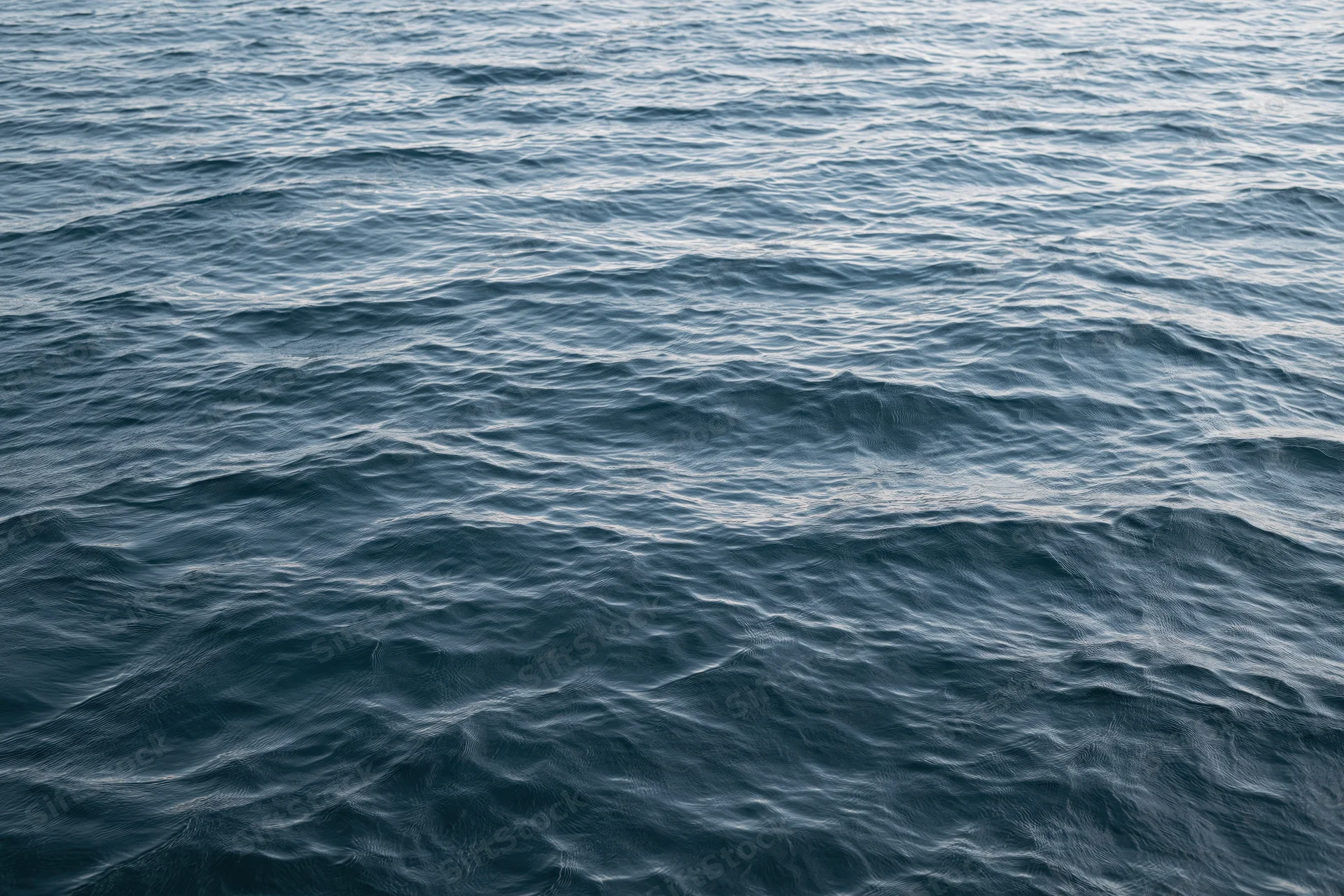 Calm ocean surface with gentle waves and ripples under natural light