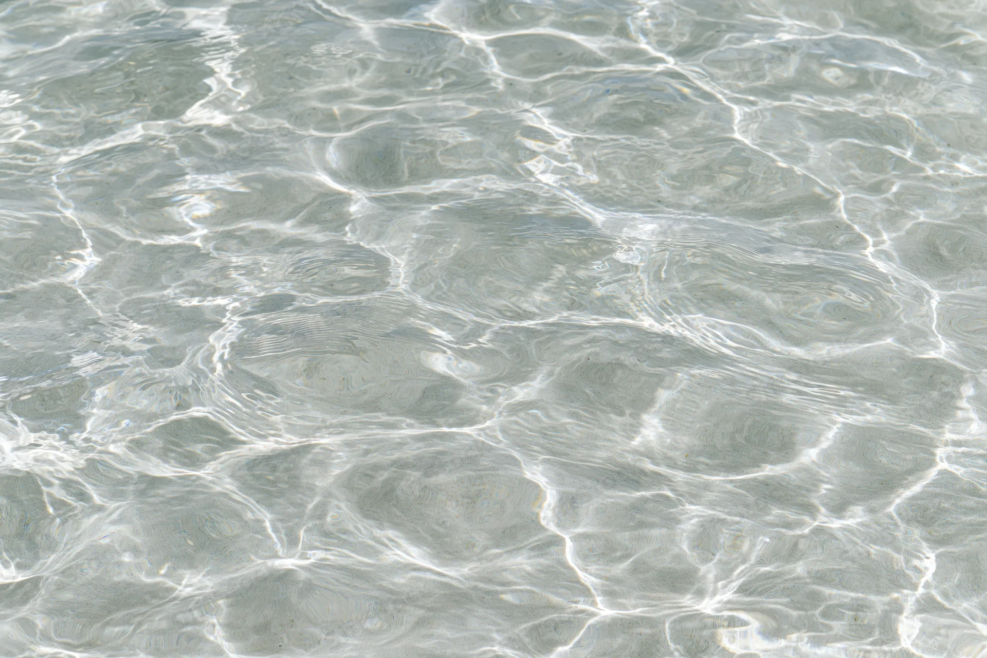 Clear shallow water surface with ripples and light reflections
