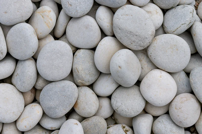 Close-up overhead view of smooth rounded river pebbles packed together