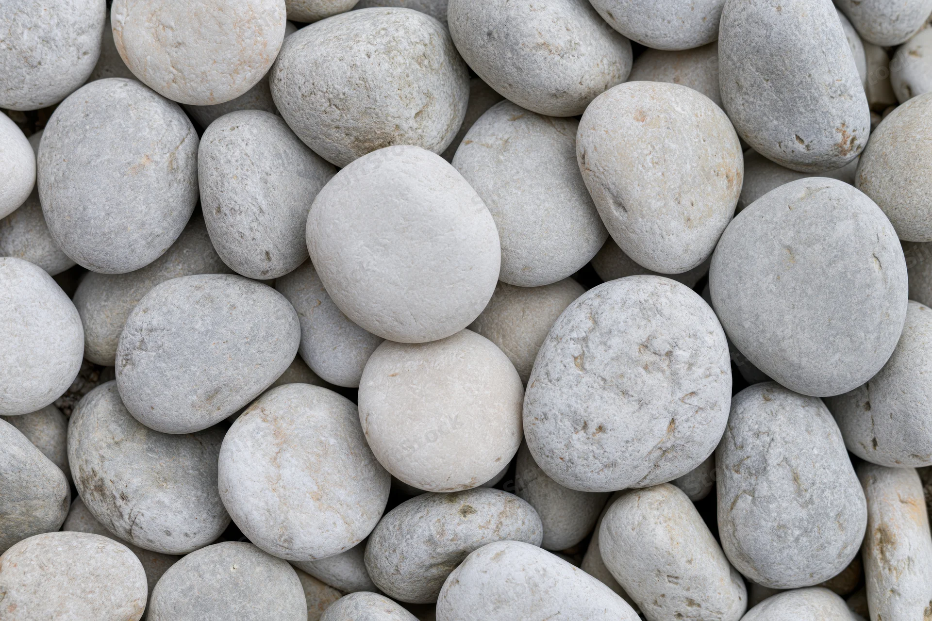 Close-up overhead view of smooth rounded river pebbles packed together