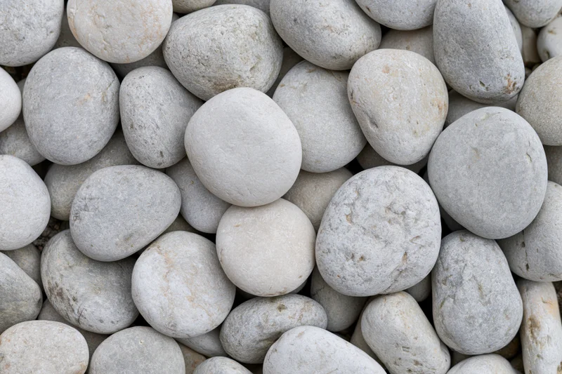 Close-up overhead view of smooth rounded river pebbles packed together
