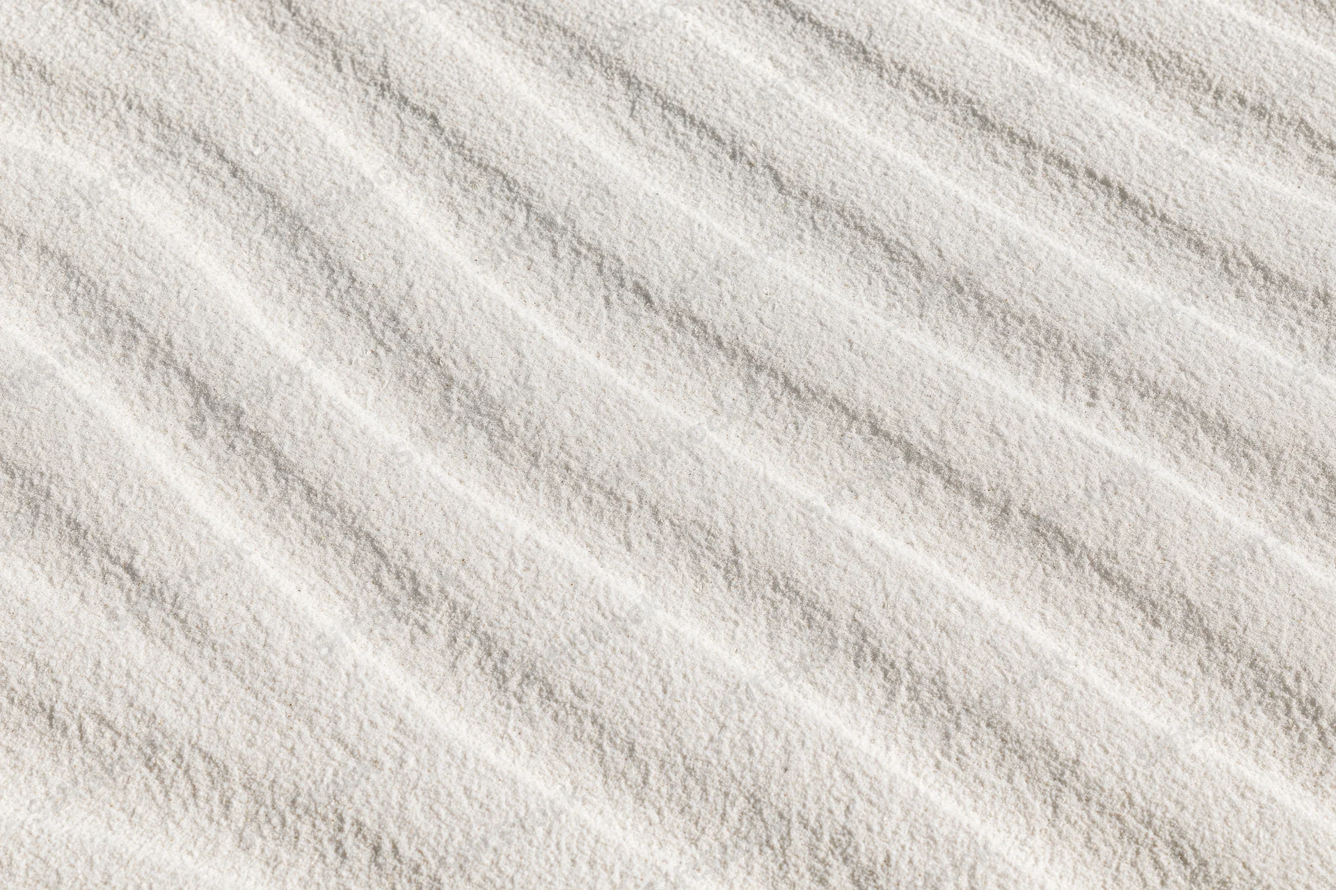 Close-up of white sand surface with wind-formed ripples