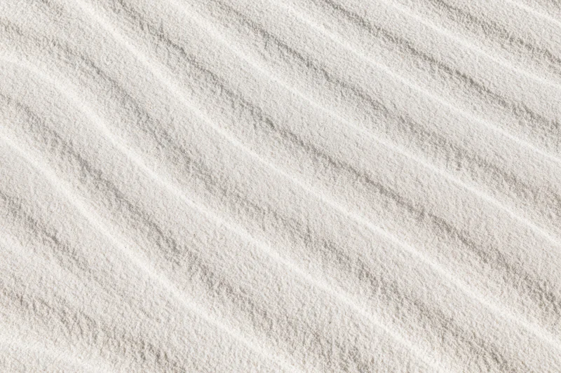 Close-up of white sand surface with wind-formed ripples