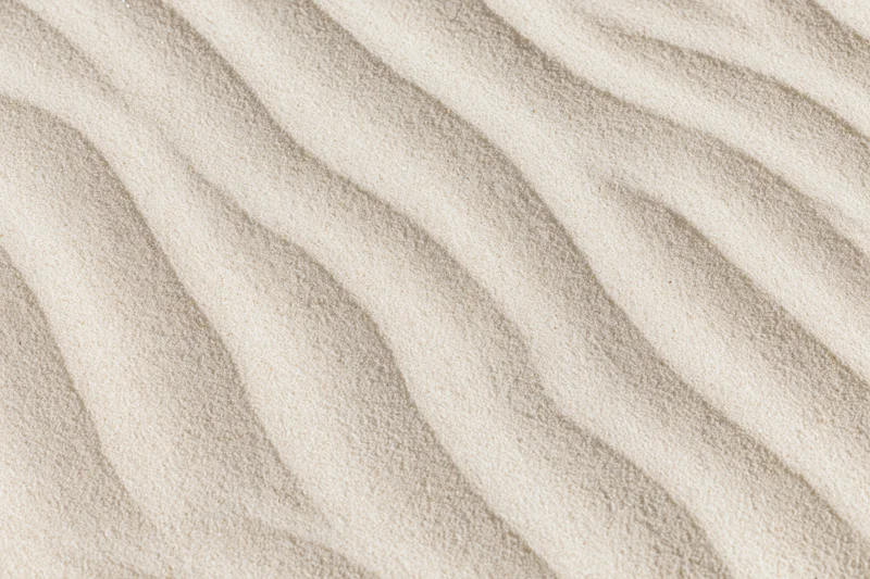 Close-up overhead view of wind-rippled desert sand surface showing natural patterns and texture