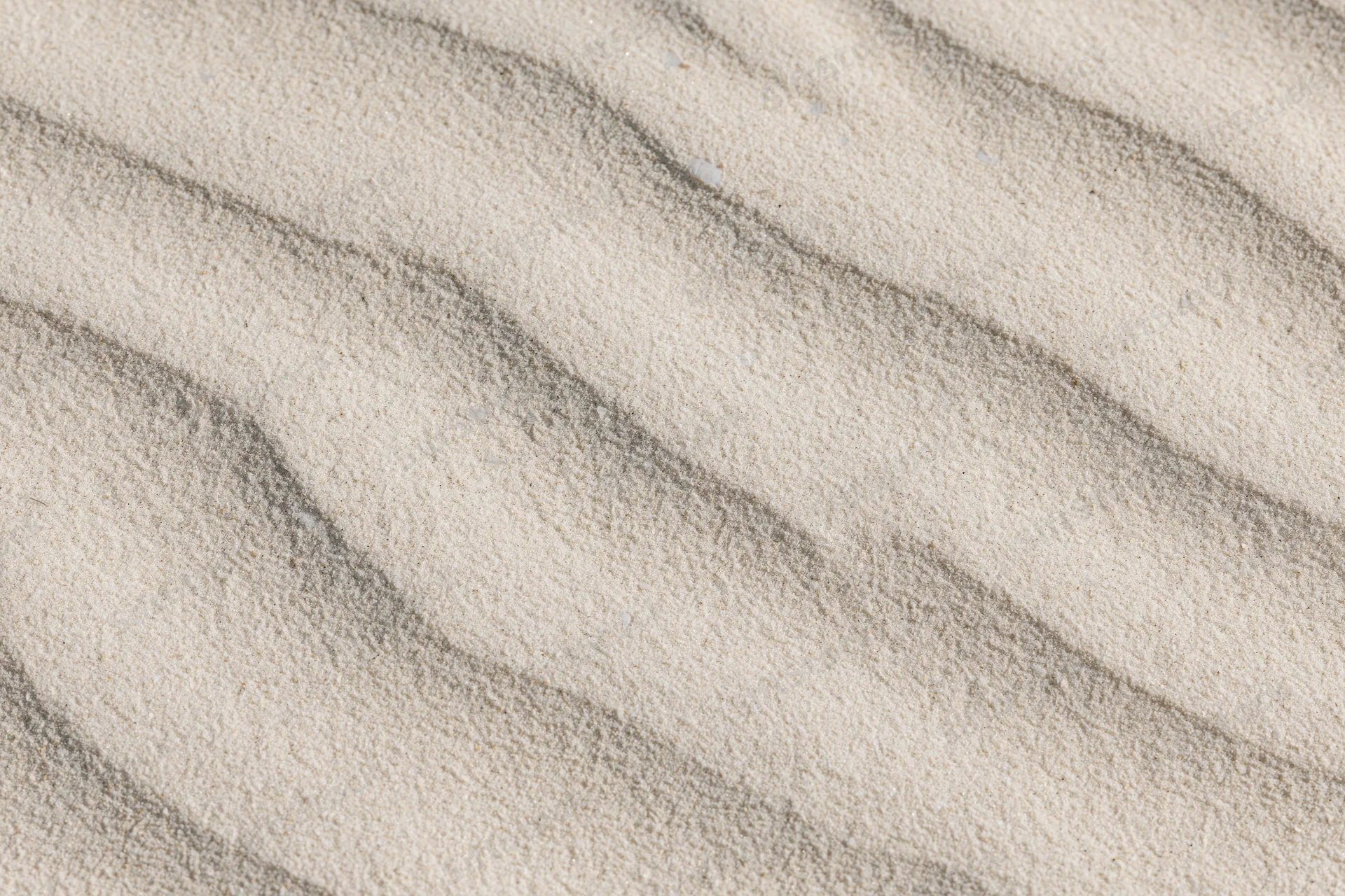 Close-up overhead view of wind-rippled desert sand surface showing natural texture and wave patterns