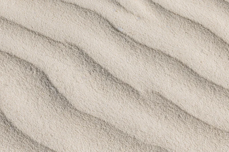 Close-up overhead view of wind-rippled desert sand surface showing natural texture and wave patterns