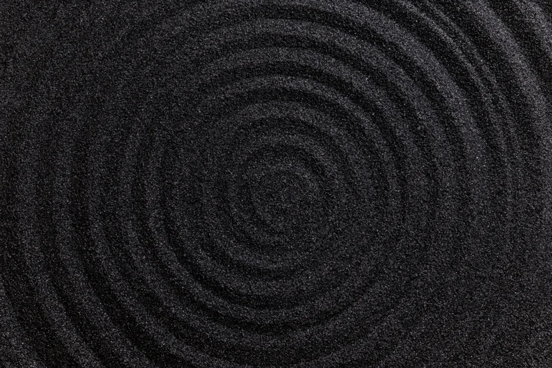 Concentric circles raked into dark black volcanic sand center