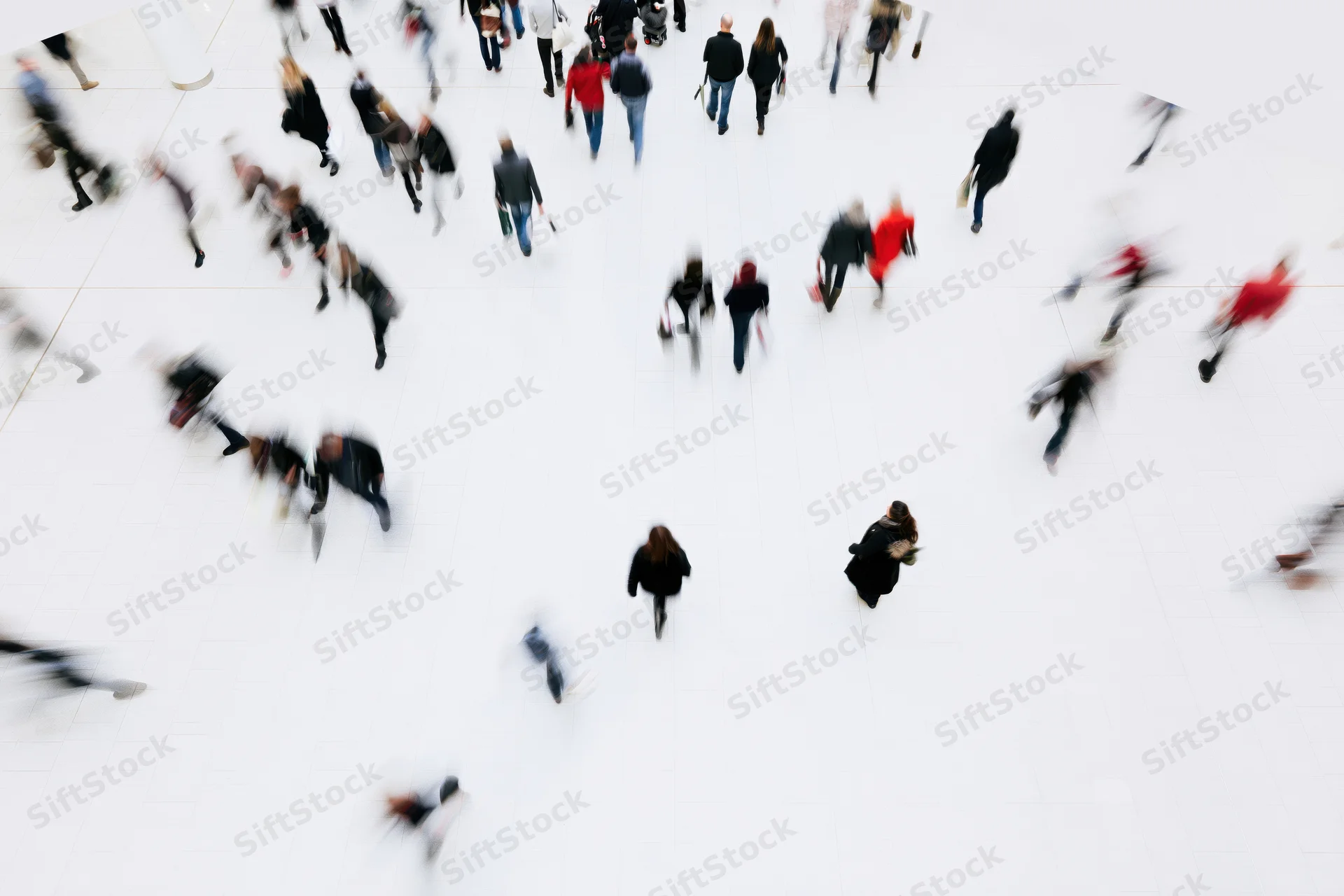 Shoppers moving across a large white atrium in an indoor mall