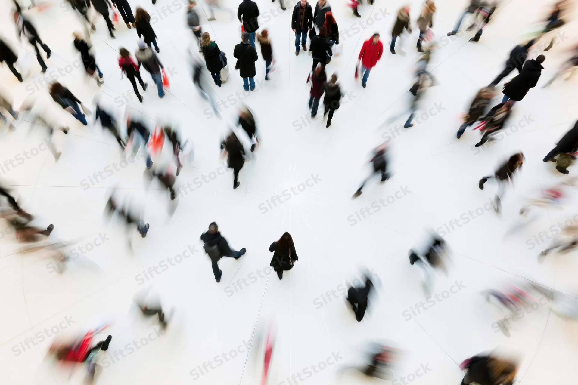 Overhead view of shoppers walking in a large white mall atrium with motion blur