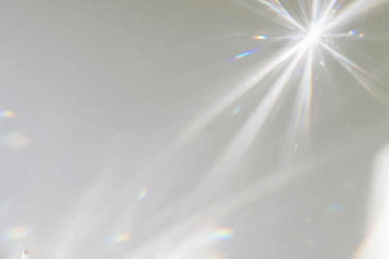 Crystal light refraction patterns cast across a plain matte surface