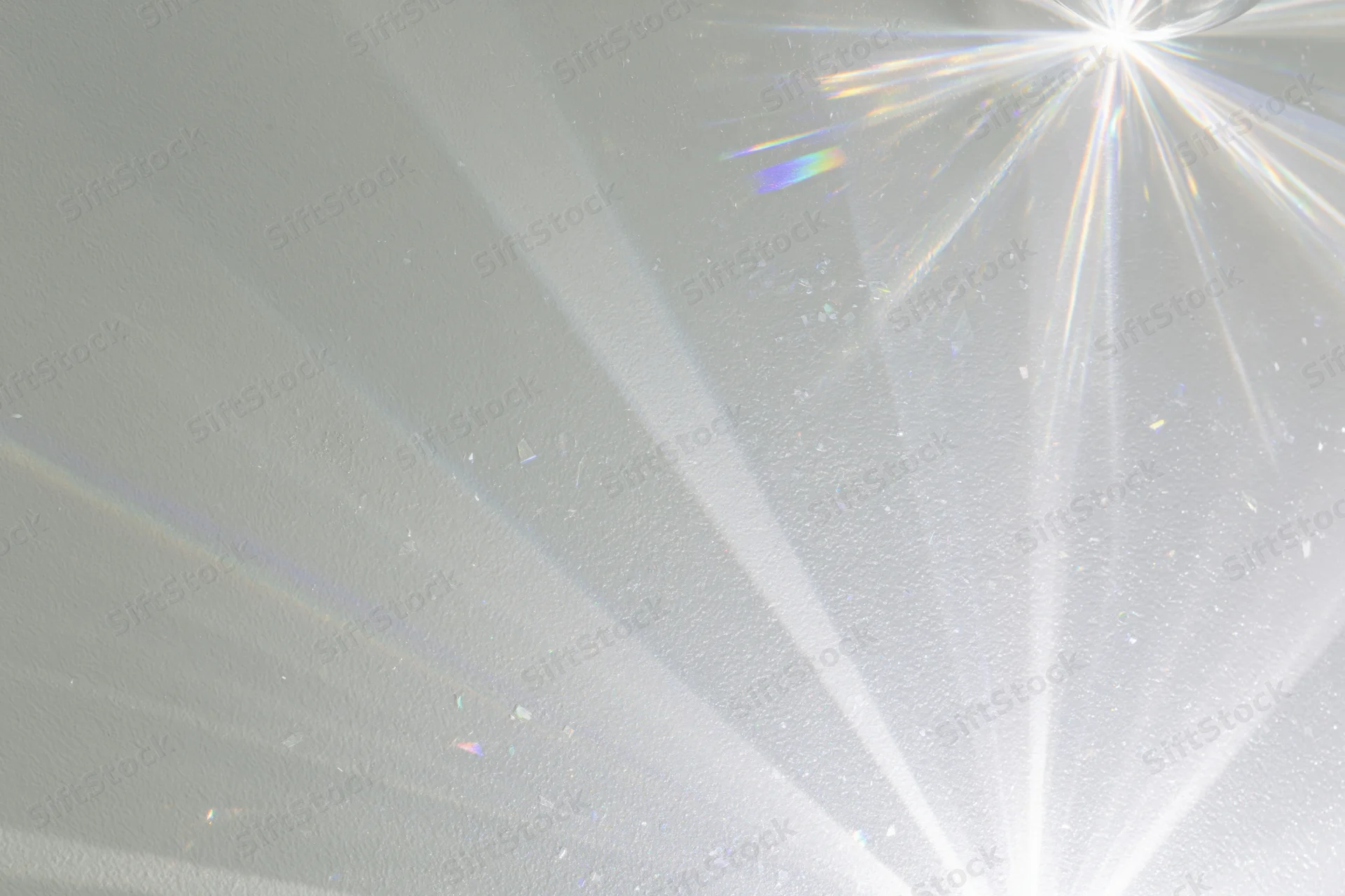 Crystal light refraction patterns cast across a plain matte surface