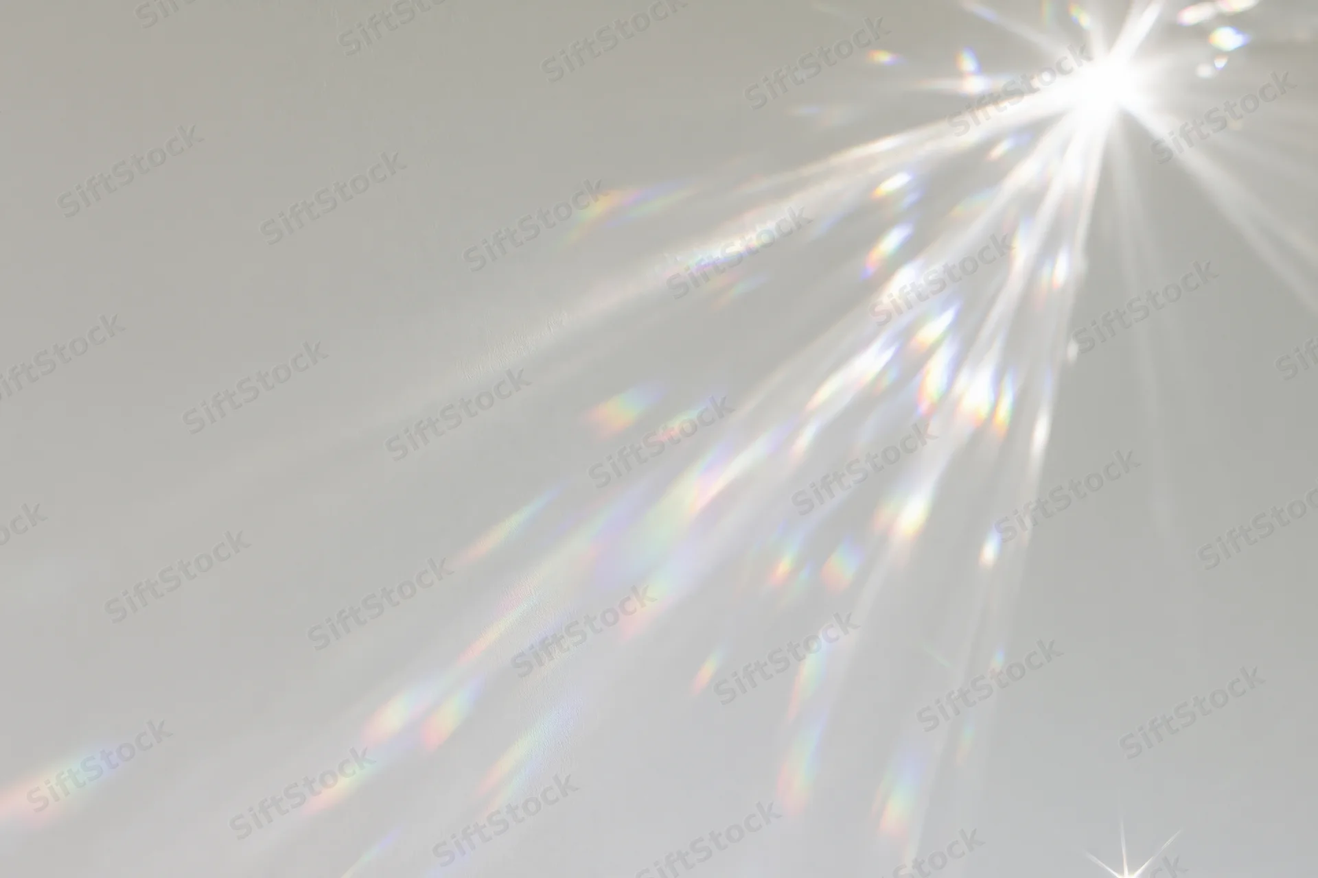 Crystal light refraction patterns cast across a plain matte white surface