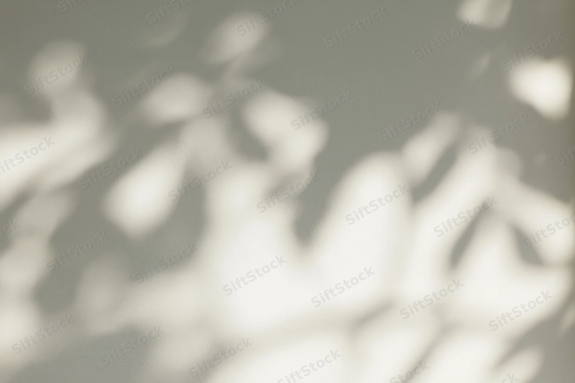 Dappled sunlight filtering through leaves casting soft shadows on a surface