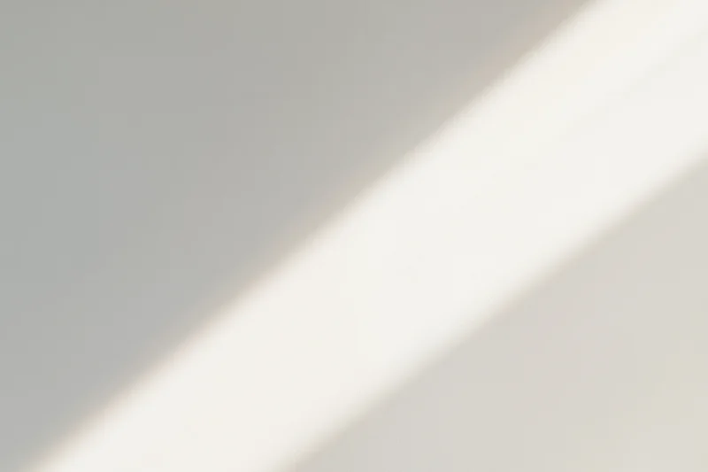 Diagonal band of natural sunlight falling across a plain gray interior surface