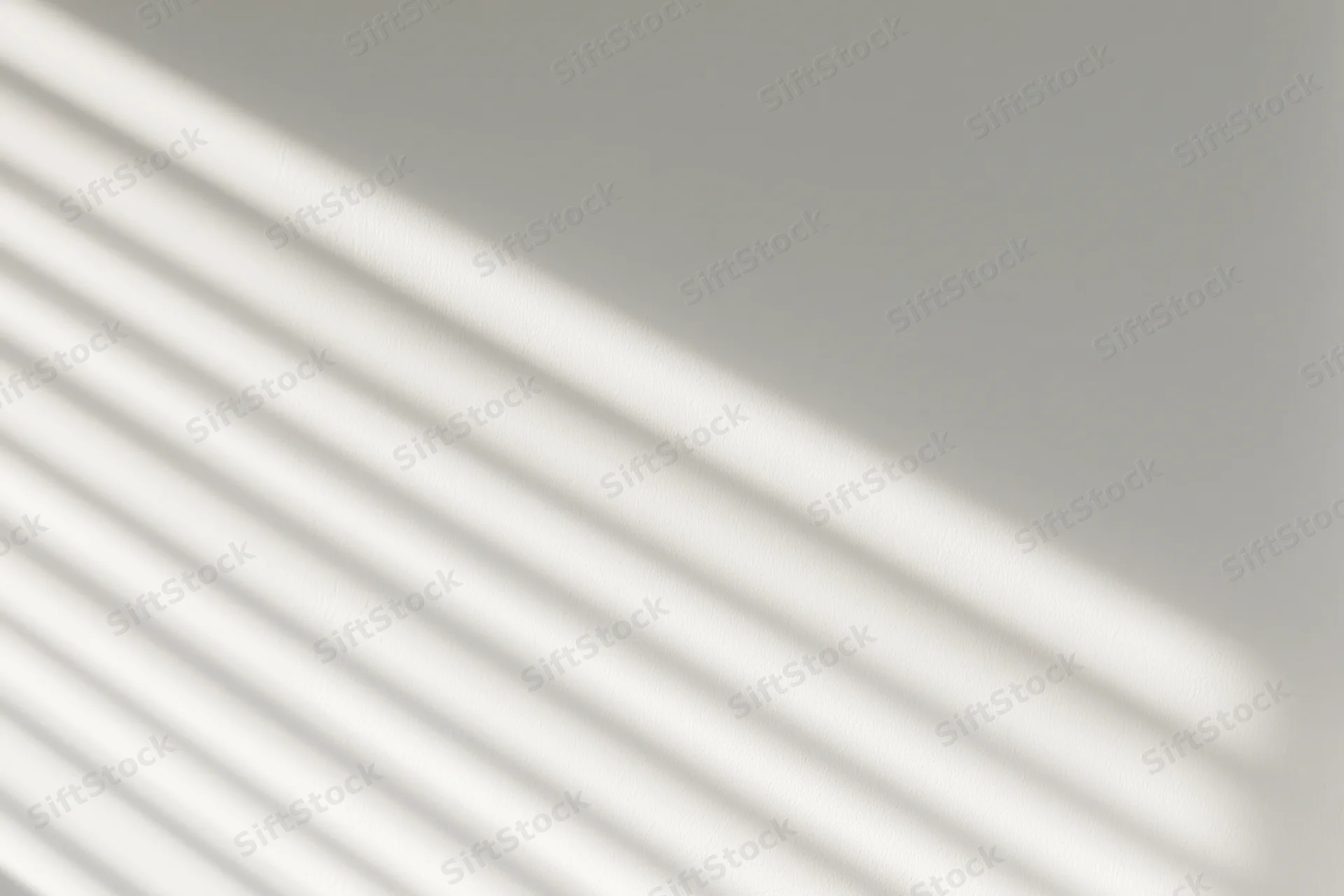 Diagonal light stripes from window blinds on a plain wall