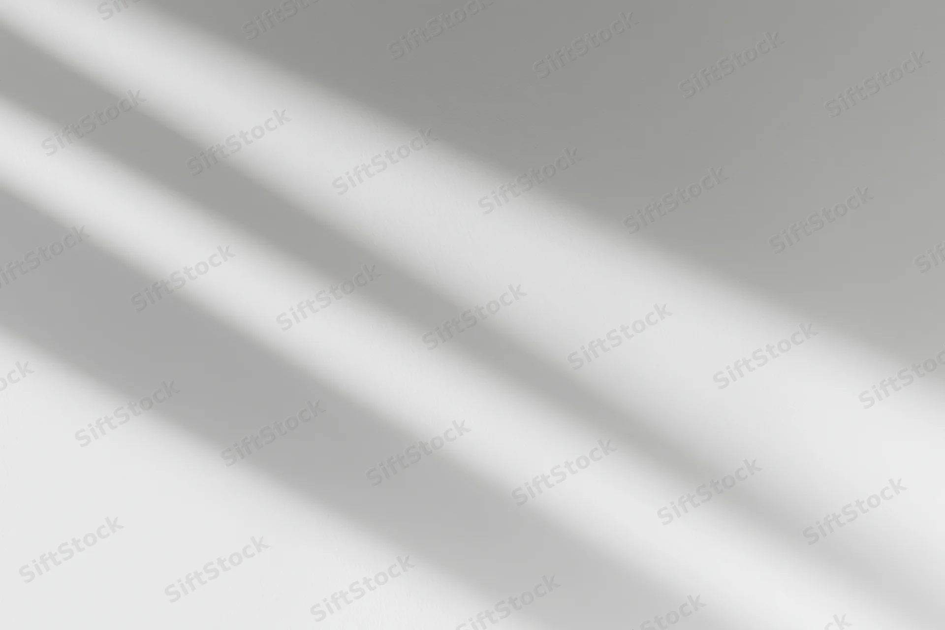 Diagonal window light casting soft overlapping shadow streaks across a plain surface