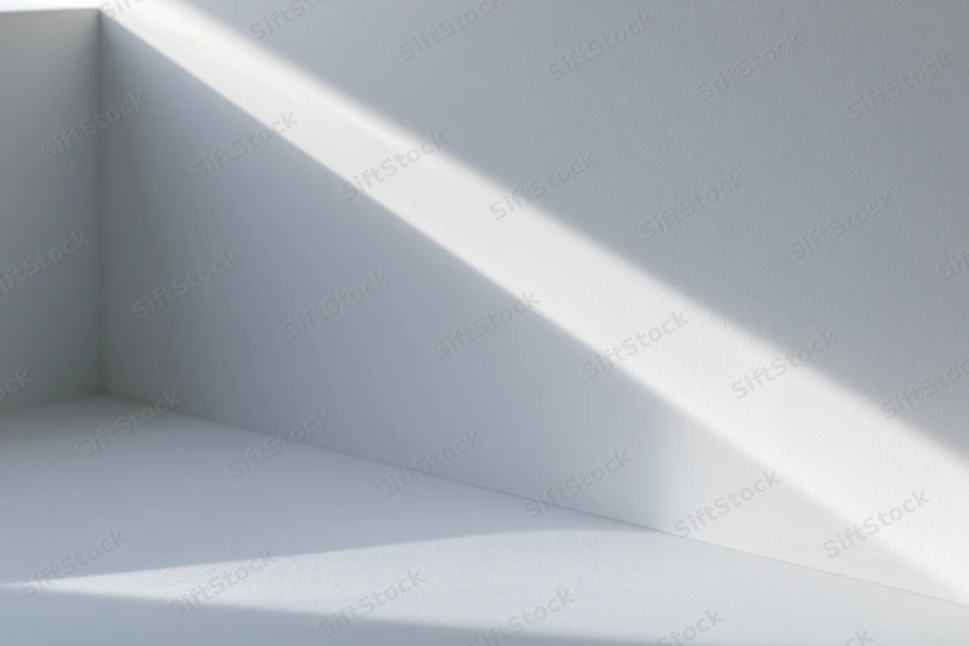 Diagonal beam of sunlight casting a soft shadow across a white interior corner