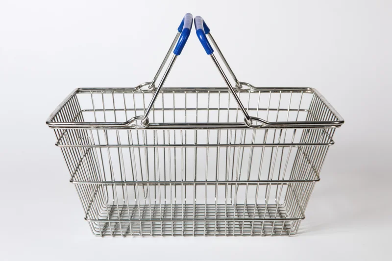 Empty chrome wire shopping basket with raised blue-handled grips isolated on white background