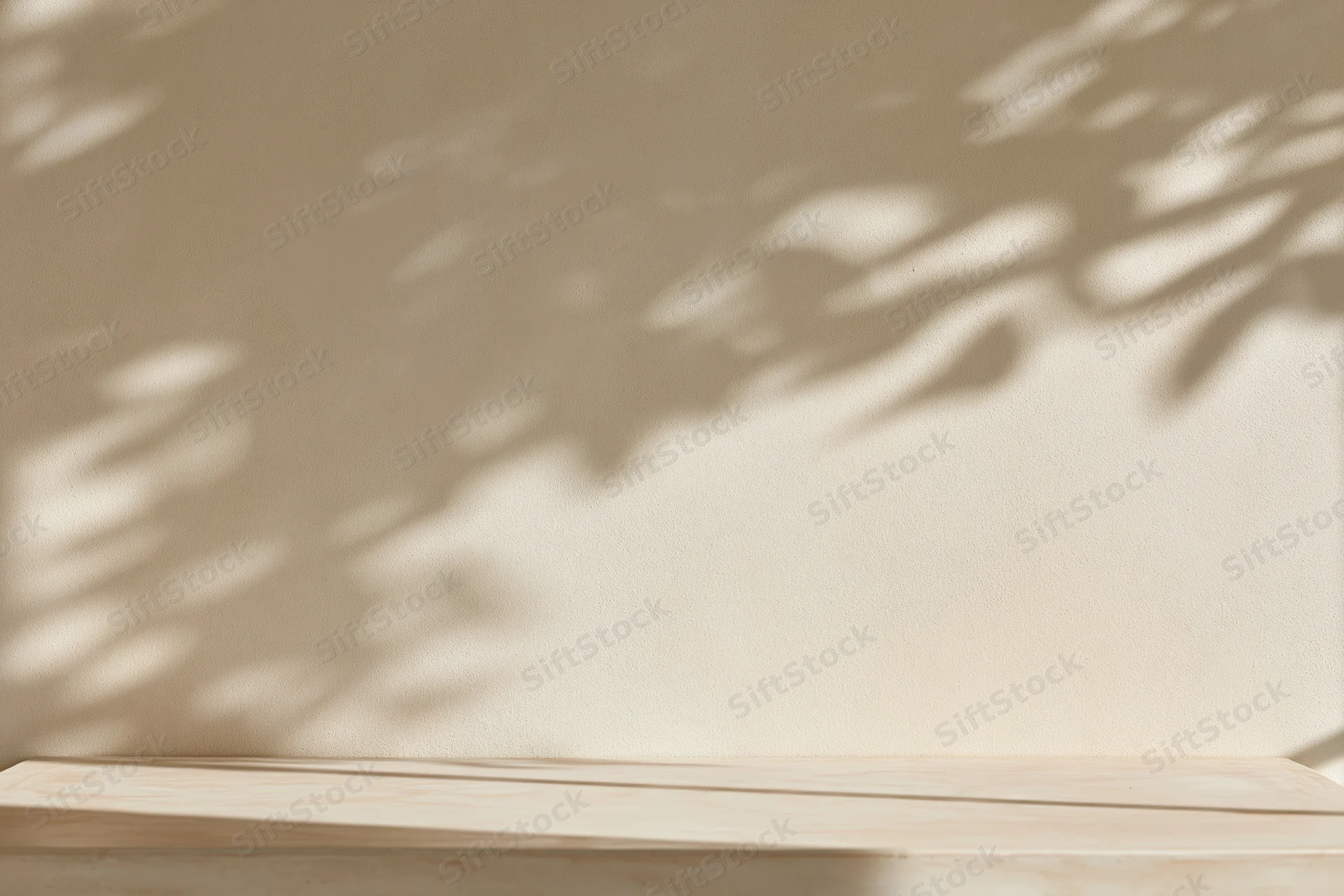 Smooth cream plaster wall with wooden shelf and dappled leaf shadows