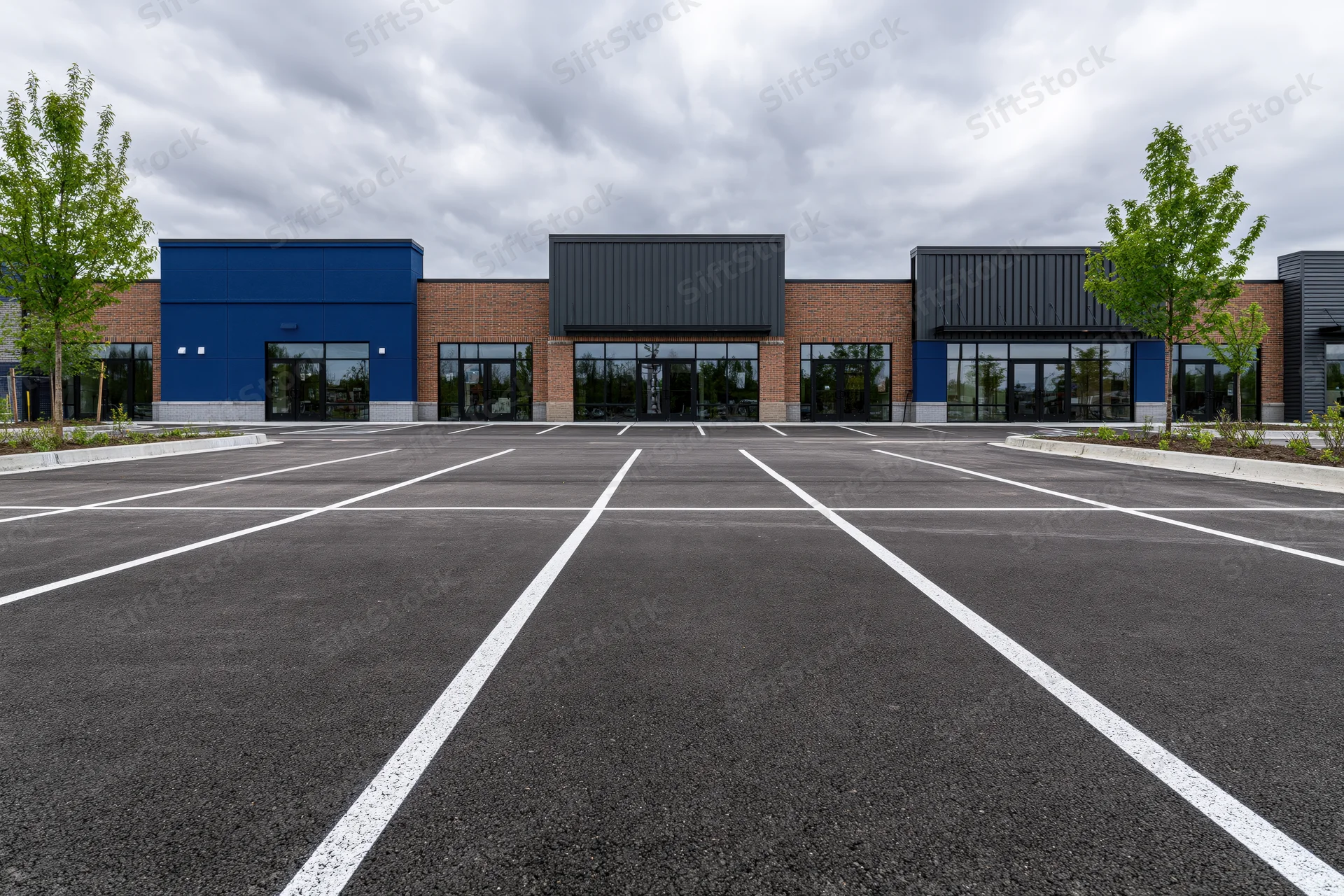 Empty parking lot with white lines in front of a modern strip mall building