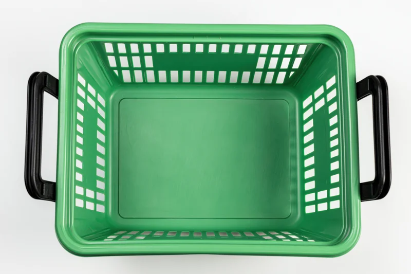 Empty green plastic shopping basket viewed from above on white background