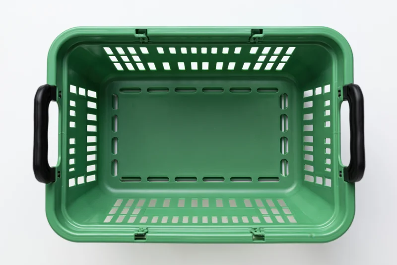 Empty green plastic shopping basket viewed from directly above on white background