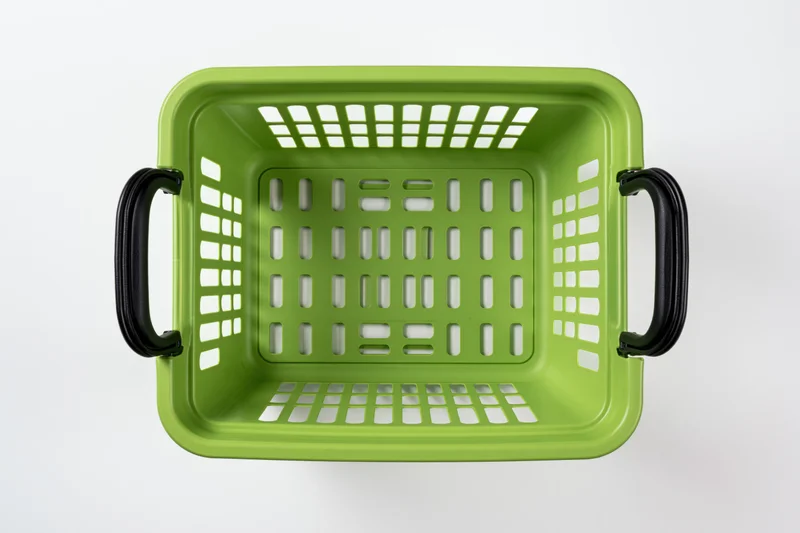 Empty green plastic shopping basket viewed from directly above on white background