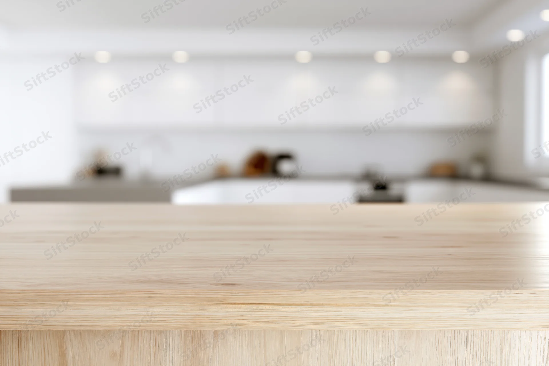 Light wood countertop in sharp focus with blurred modern kitchen background
