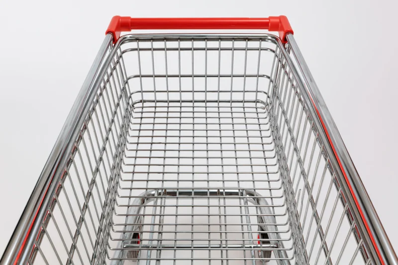 Empty metal shopping cart viewed from above against white background