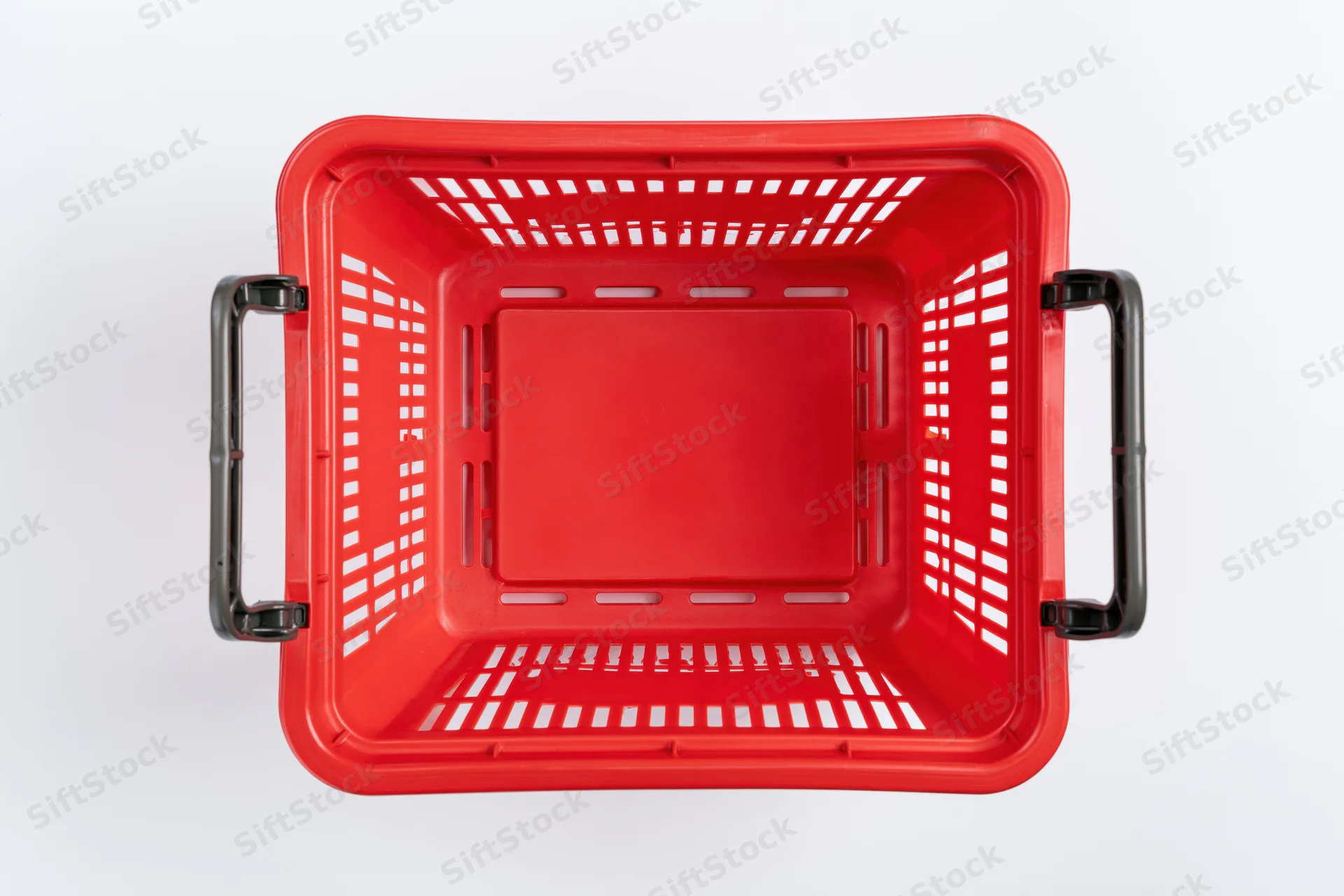 Empty red plastic shopping basket viewed from above on white background