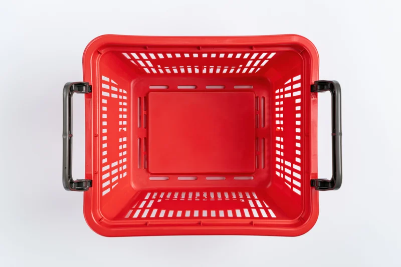 Empty red plastic shopping basket viewed from above on white background