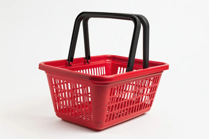 Red plastic shopping basket with black handles on white background
