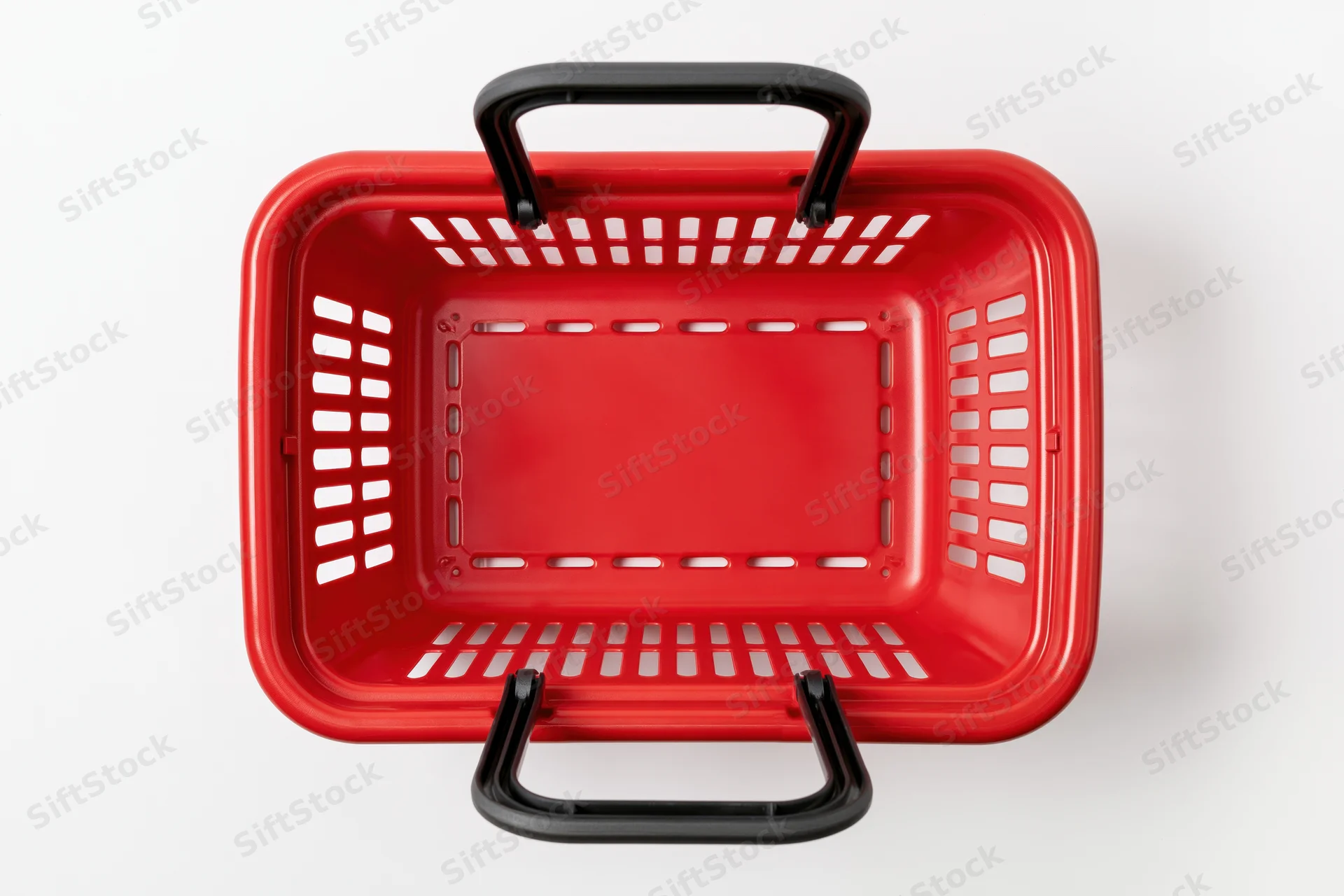 Empty red plastic shopping basket with black handles on white background