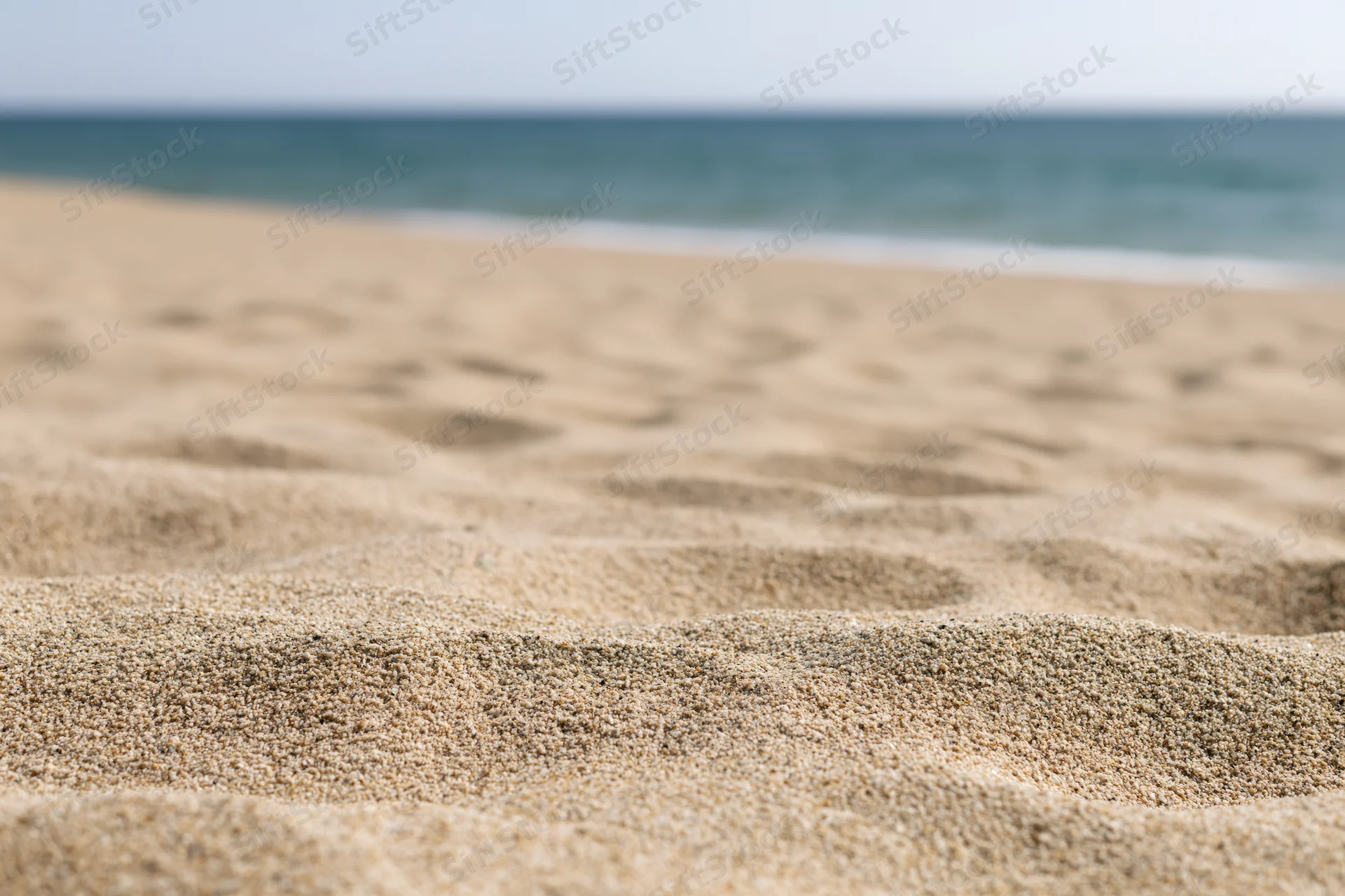 Sand on a beach with ocean in the background