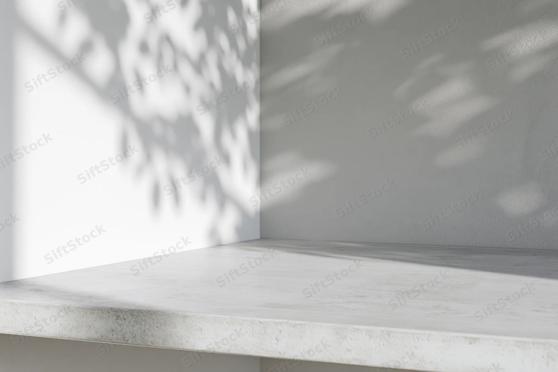White concrete shelf in a corner with dappled leaf shadows on the wall