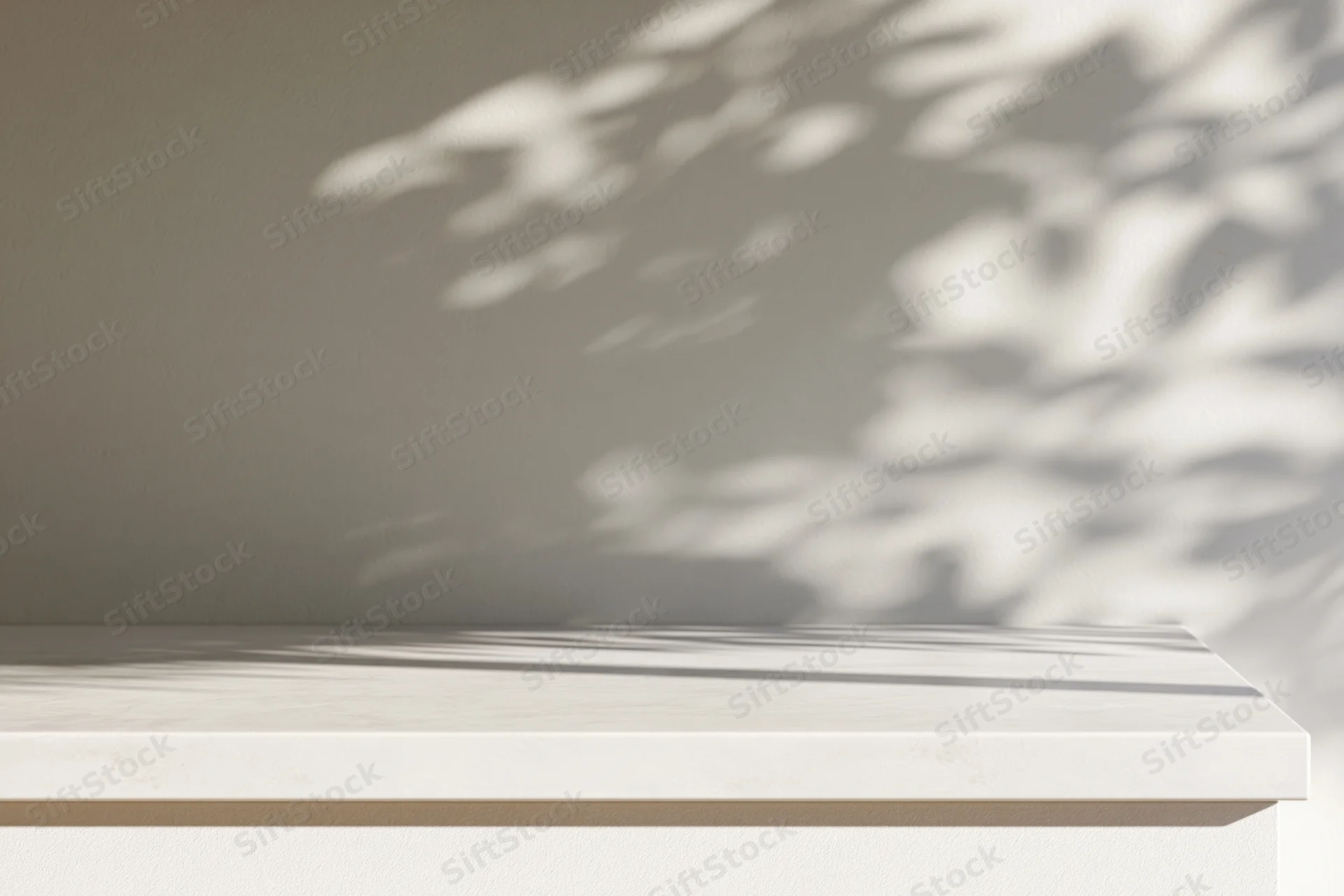 White concrete surface with dappled leaf shadows on a beige wall, interior setting