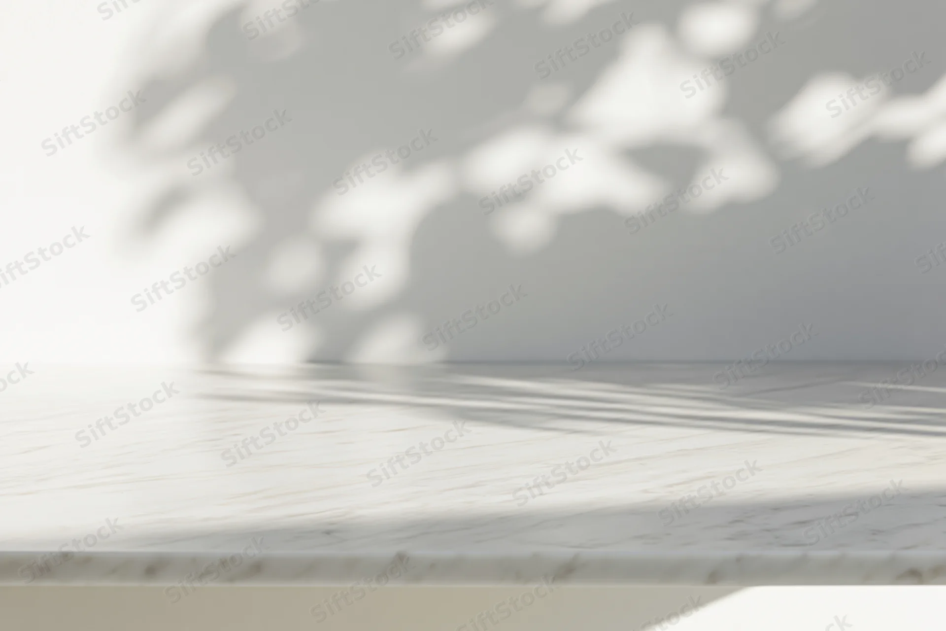 White marble tabletop with dappled sunlight shadows in a minimalist interior