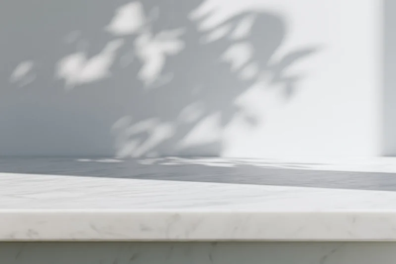 White marble tabletop with leaf shadows in a bright minimalist interior