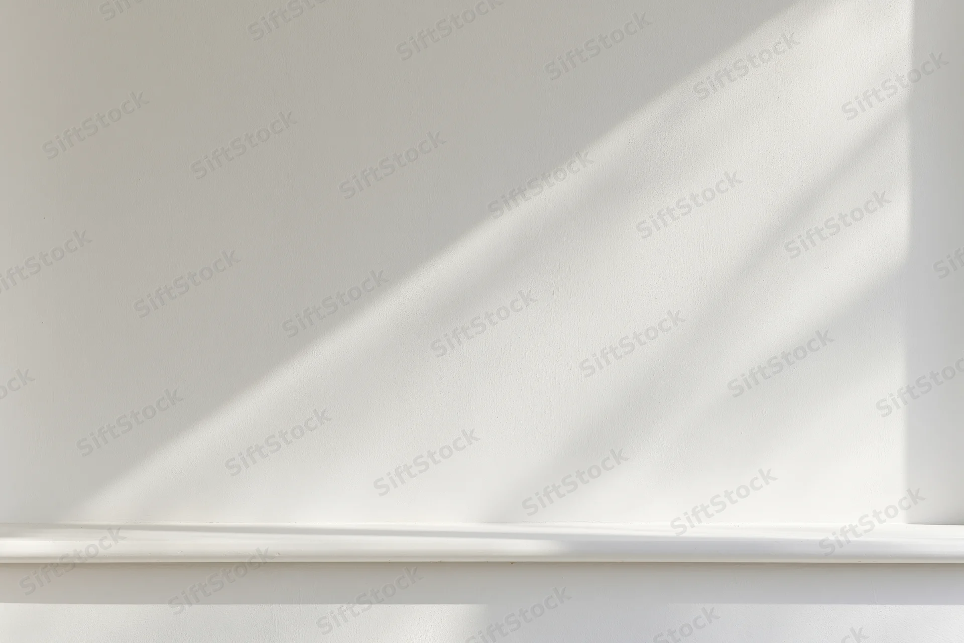 Empty white shelf against a smooth white wall in a minimalist studio space