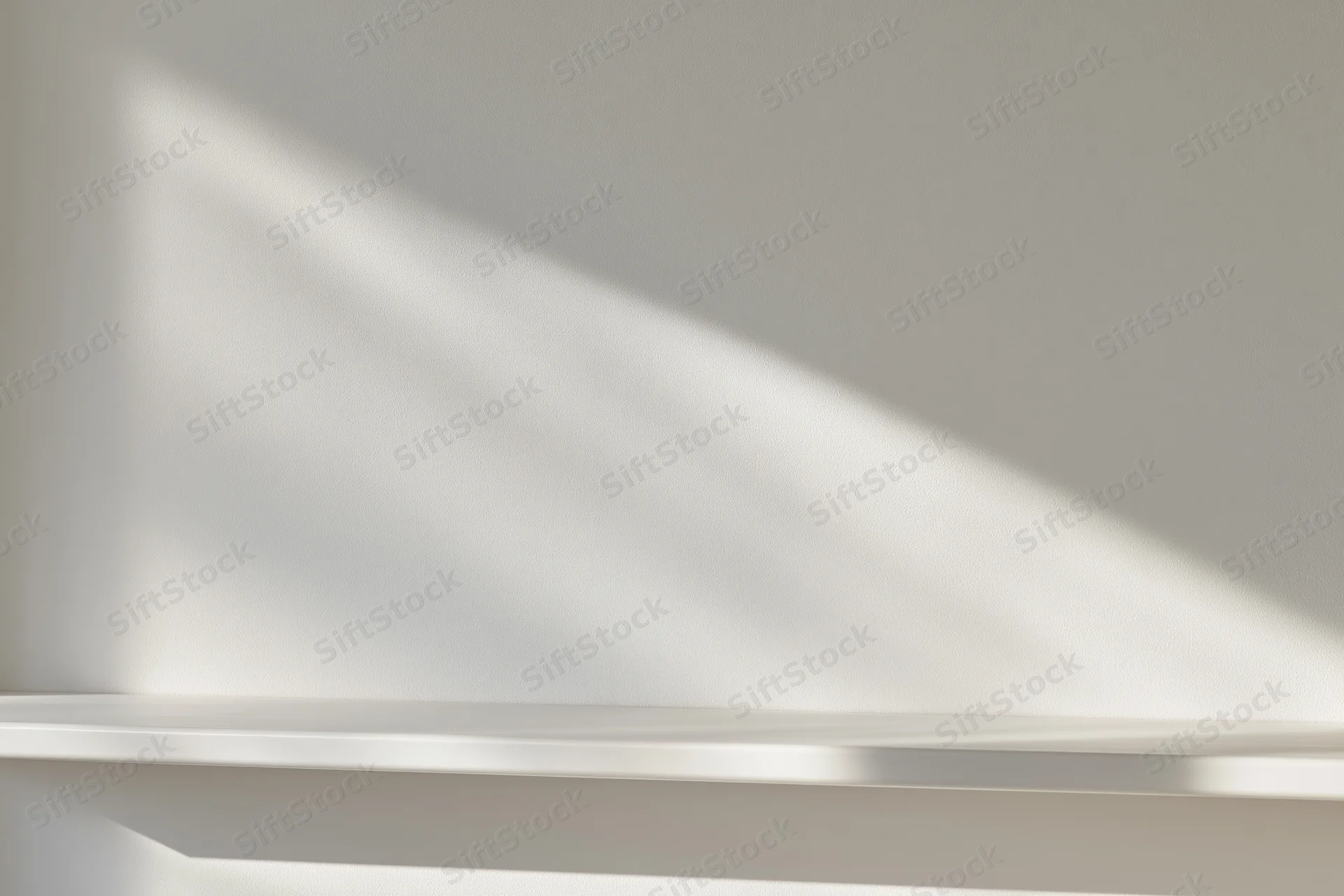 Empty white shelf against a smooth white wall in a minimalist studio space