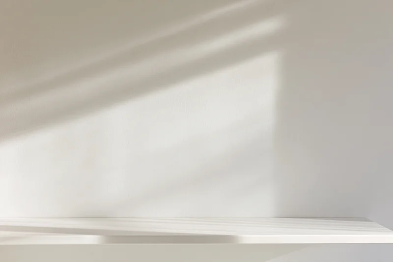 White shelf mounted on a smooth wall with soft shadows from natural light